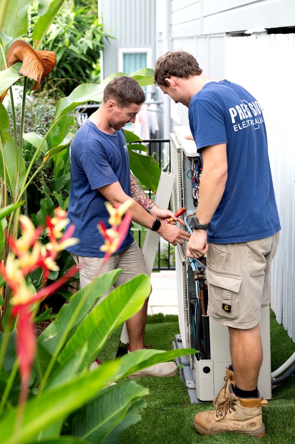 Electrician working on a heat pump hot water system