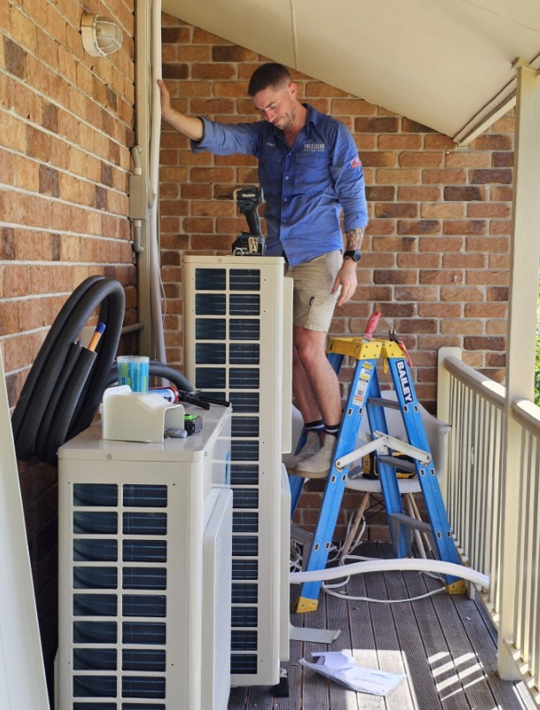 Technician making the final connections on a ducted air conditioning system